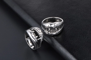 Macro shot of gothic crocodile tooth rings in polished silver steel on black leather