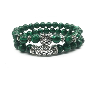 Detailed macro view of owl charm and green malachite beads on a double layer bracelet