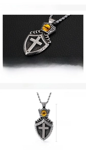 Macro view of vintage stainless steel shield pendant with yellow evil eye and cross detail