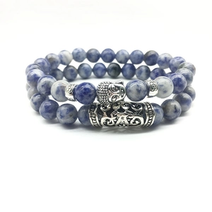 Detailed macro of natural blue sodalite beaded bracelets with silver Buddha head charm
