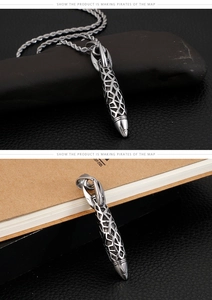 Macro shot of retro stainless steel rocket pendant with intricate hollow geometry patterns
