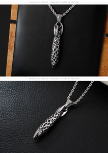 Detailed view of silver stainless steel rocket pendant on twist chain over black leather