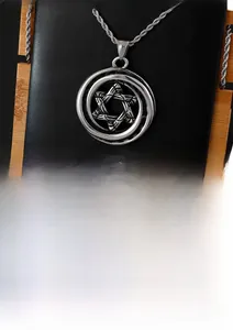 Macro detail of punk hexagram star pendant in vintage finish steel with rope chain