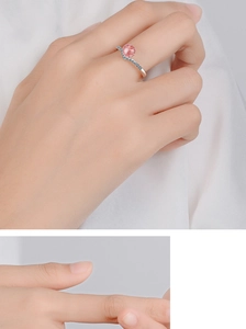 Close-up of wavy silver band ring with strawberry quartz and pavé diamonds on model hand