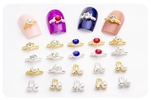 Détail de bijoux d'ongles en alliage avec couronnes et lettres D ornées de perles
