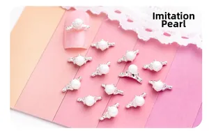 Vue détaillée des perles de décoration pour ongles sur base argentée et ongles roses
