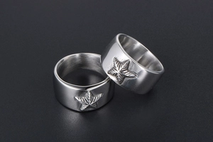 Gros plan sur la bague large en acier inoxydable poli avec motif d'étoile de mer en relief