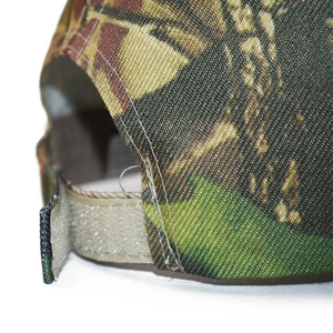 Close-up of camouflage baseball cap featuring adjustable hook and loop fastener back