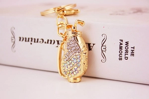 Close-up of golden golf bag keychain with sparkling colorful rhinestones on book