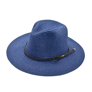 Dettaglio cappello di paglia blu scuro con cinturino in pelle e fibbia in metallo oro