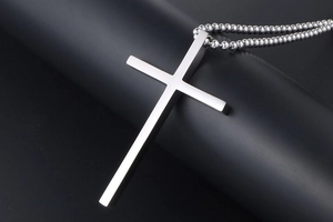 Detailed view of a silver stainless steel cross pendant on a matching bead chain