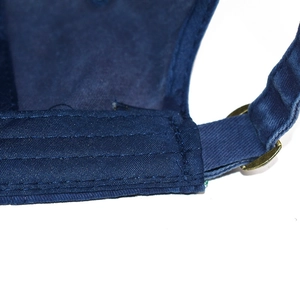 Detail of the adjustable bronze metal buckle and navy blue cotton twill on baseball cap
