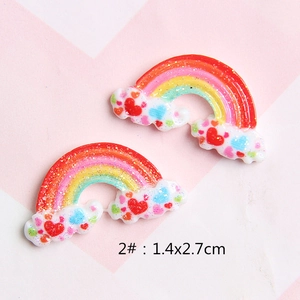 Macro detail of 1.4x2.7cm rainbow cloud resin charms with glitter finish and hearts