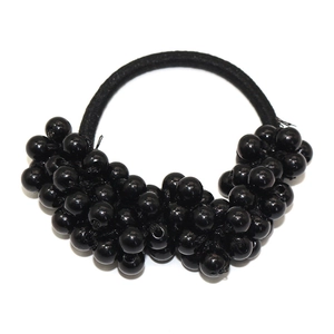 Elastic beaded hair tie with shiny black pearls and woven texture on white background