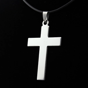 Polished stainless steel cross pendant necklace on a black cord over dark background