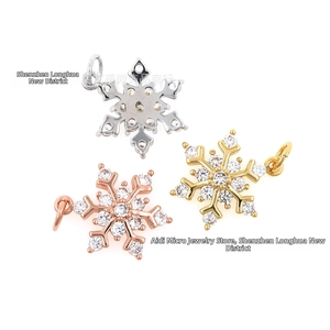 Detailed macro view of snowflake charms with micro-pave zircons in gold, silver, and rose gold