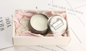 Tin scented candle in warm white soy wax placed inside a premium gift box with pink fill