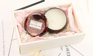 Detailed view of aromatic candle in vintage tin box within elegant gift box packaging