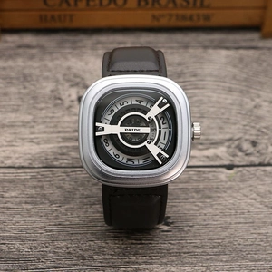 Macro detail of silver square dial with unique turntable time display and leather strap