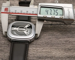 Close-up of punk square dial watch measuring 47.75mm with a digital caliper and leather strap