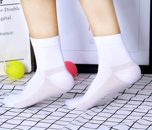 Gros plan de chaussettes blanches avec talon gris renforcé sur une surface à motifs