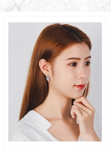 Close-up of a model wearing purple crystal grape stud earrings with sparkling stones