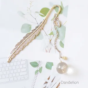 Silver metal feather bookmark featuring a glass pendant with real dandelion seeds
