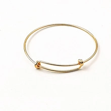 Detailed view of adjustable golden wire bracelet with sliding knot and polished finish
