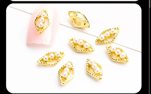 Macro detail of alloy hollow rhombus nail art charms with three white pearls in 8-piece set