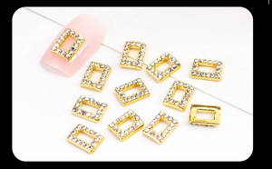 Macro detail of gold alloy nail charms with sparkling rhinestones and aurora crystals