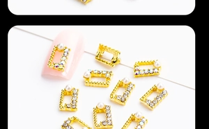 Macro detail of alloy nail art charms with marquise pearls and rhinestones on pink nails