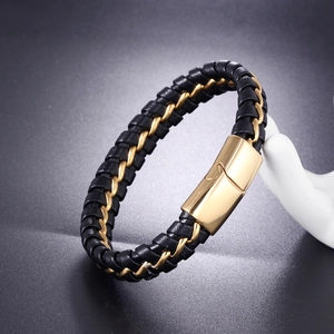 Detail of black leather and gold stainless steel braided bracelet with magnetic clasp