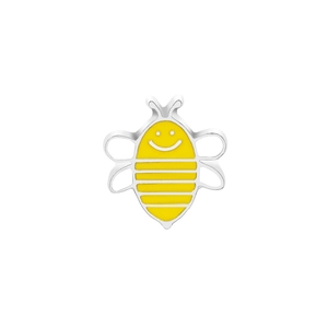 Detail shot of a cartoon bee brooch with silver trim and yellow enamel finish