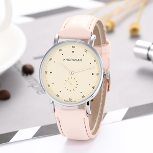 Close-up of a women's quartz watch with pink leather strap and cream dial in a lifestyle setting