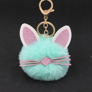 Close-up of mint green plush kitten keychain with pink glitter ears and gold clip