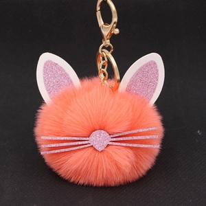 Detail of fluffy orange pink cat head keychain with glitter ears and whiskers