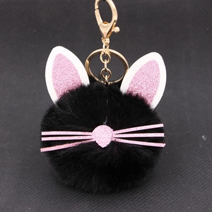 Close-up of black plush kitten keychain with pink glitter ears and gold metal clip