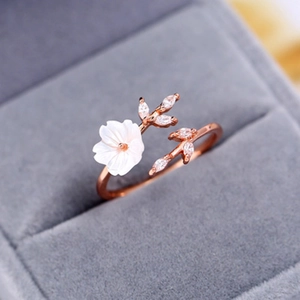 Rose gold adjustable ring featuring white shell flower and cubic zirconia leaf design