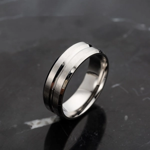 Vue macro d'une bague homme 8mm en acier inoxydable avec rainure mate sur marbre noir