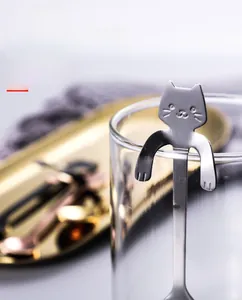 Detail of creative cat-shaped 304 stainless steel spoon hanging on a glass cup rim