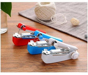 Drie kleurrijke handmatige mini naaimachines in rood, blauw en wit op houten tafel