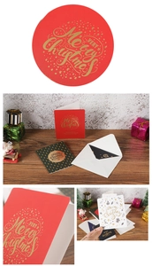 Close-up of gold foil Merry Christmas cards in festive red and green colors