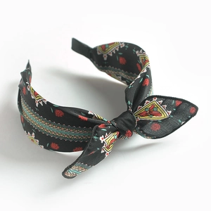 Close-up of retro floral pattern headband with bow detail on white background