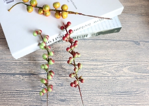 Macro detail of artificial berry branches with realistic gradient texture on wooden surface