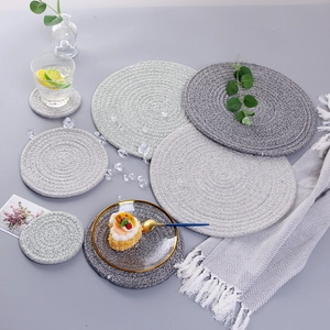 Detail view of woven cotton heat-resistant table mats and coasters in grey and beige tones