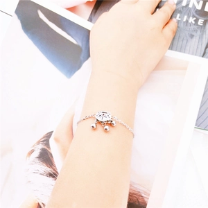 Silver longevity lock bracelet with Fu character and small bells shown on a wrist