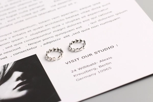 Detailed view of two adjustable S925 sterling silver rings with linked heart patterns