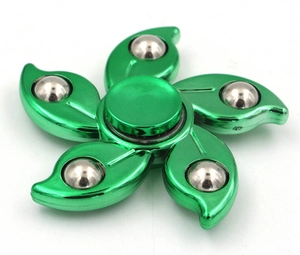 Close-up of green 5-blade fidget spinner with polished metal steel balls on white background