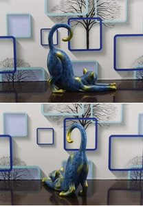 Detail of blue marble-textured resin cat sculpture with gold accents in a stretching pose