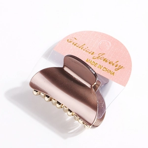 Elegant acrylic shark hair claw in bronze pink finish with subtle gold bead accents